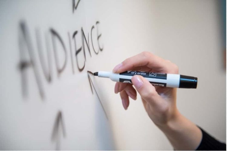 Person using a whiteboard and marker to brainstorm their content marketing approach